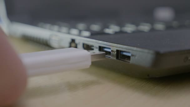 Trzymać ręce chłopca nastolatek podłączenie kabla transmisji danych usb w swoim laptopie, aby skopiować pliki, a następnie odłączyć go — Wideo stockowe