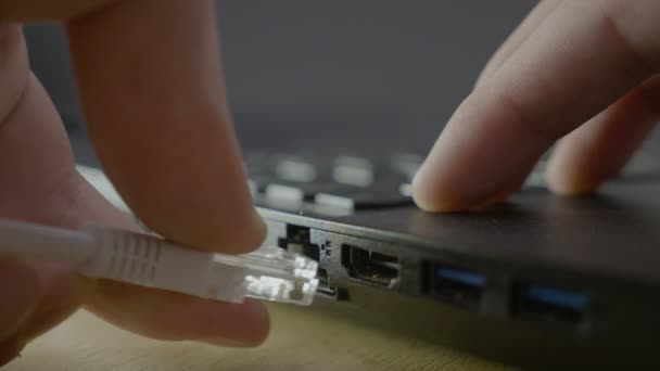 Man Finger stecken das Ethernet-Kabel in den Port seines Laptops, um die Verbindung zu überprüfen und dann abzuziehen — Stockvideo