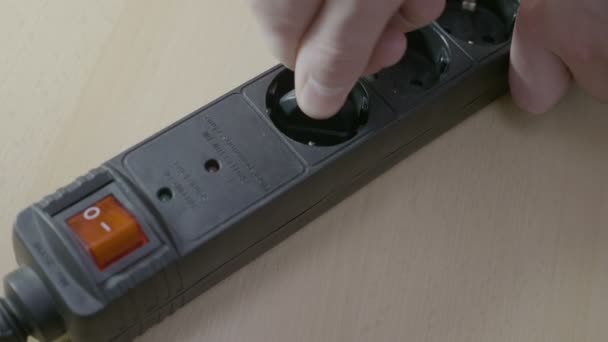 Närbild av plugging i sladdar till en svart förgreningsdosa samtidigt aktivera el och sedan att stänga av och koppla bort det — Stockvideo