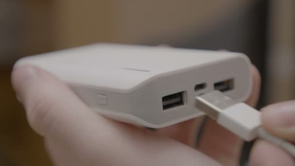 Закрыть мужские руки подключение в кабель USB в банк питания, чтобы пополнить свой телефон — стоковое видео