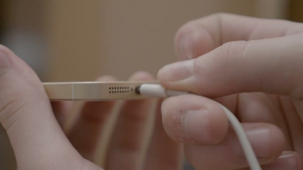 Vingers het plaatsen van de USB-kabel in de poort van zijn slimme mobiele telefoon te downloaden van de beelden en ruimte maken voor nieuwe foto 's — Stockvideo