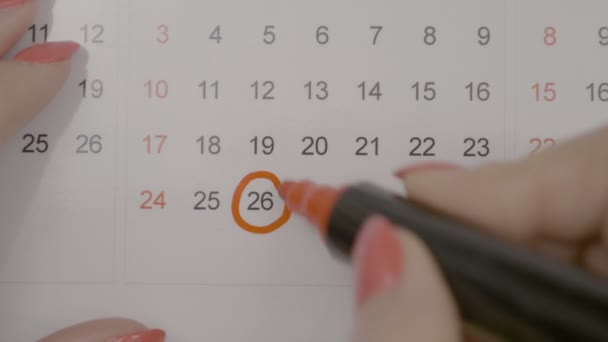 Vista superior de las manos de mujer firmando el día del nacimiento en el calendario y contando los días para ello — Vídeo de stock