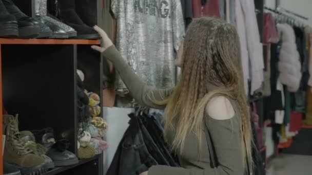 Roztomilá mladá žena hledá boty a oblečení kupovat, nakupovat v thrift shop — Stock video