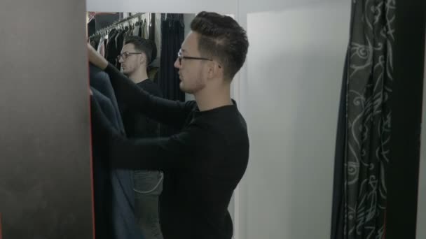 Vonzó fiatal vállalkozó üzleti ember kipróbálás különböző dzsekik a shopping mall, és szerzés kész részére a következő üzleti találkozó — Stock videók