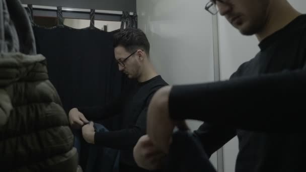 Mužské obchodní muž dělá nakupování v obchodě a při rozhodování, který z oblečení nejlépe vyhovuje — Stock video