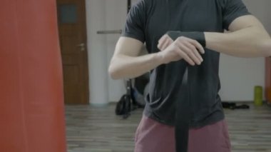 Erkek boxer eğitim spor salonunda boks bandaj ellerini etrafında sarma, yakın çekim