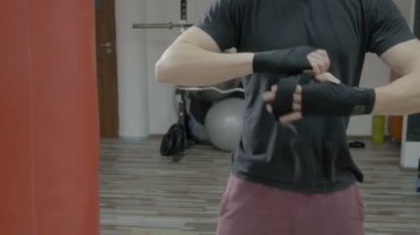 Genç boksör yetiştirmek onun eldiven koymadan önce boks bandaj ellerini etrafında kaydırma