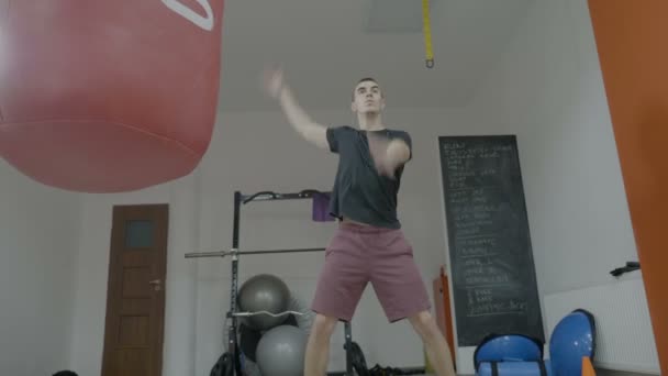 Sportos fiatal férfi boxer ruhában alkalmi edzőteremben csinál warm up gyakorlatok kar-Box gyakorlat megkezdése előtt — Stock videók