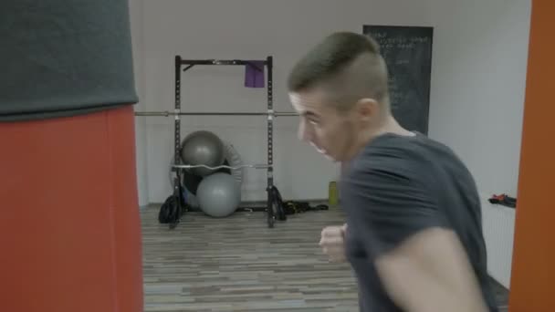 Jovem boxeador masculino boxe como exercício para a grande luta em um estúdio de ginástica para ganhar a medalha de ouro — Vídeo de Stock