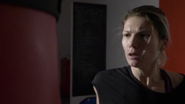 Güzel kickboks kadın kollarını yavaş sesi için bir spor salonu spor stüdyoda kum torbası ile eğitim — Stok video