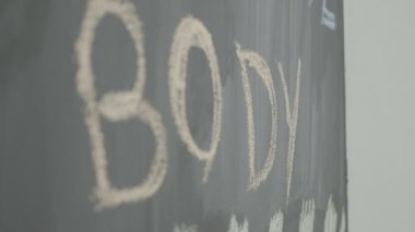 Vücut güçlü güçlü motivasyon kelimeler tebeşir ile bir spor salonunda bir kara tahta üzerinde yazılı