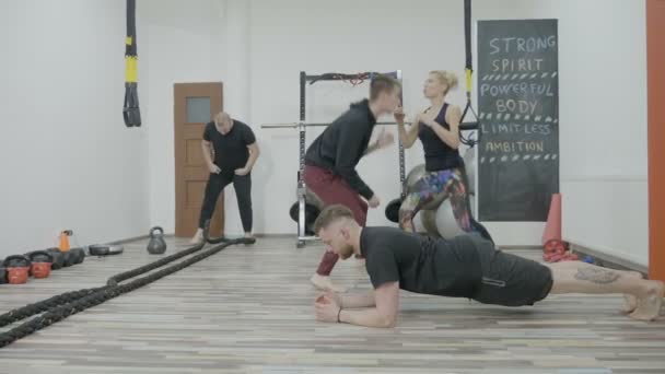 Ajuste jovens estudantes exercitando e se preparando em um ginásio cross fit para obter sua licença de treinamento pessoal — Vídeo de Stock