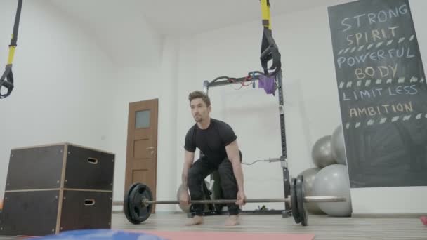 Motivado joven delgado hombre levantando pesas en un gimnasio de cross fit para ejercitar sus brazos e impresionar a las niñas — Vídeos de Stock