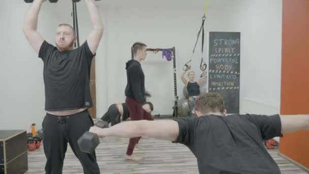 Grupa zespołu lekkoatletycznego ludzie mężczyźni i kobiety intensywnie treningu na sali gimnastycznej przy pracy wszystkich grup mięśni — Wideo stockowe