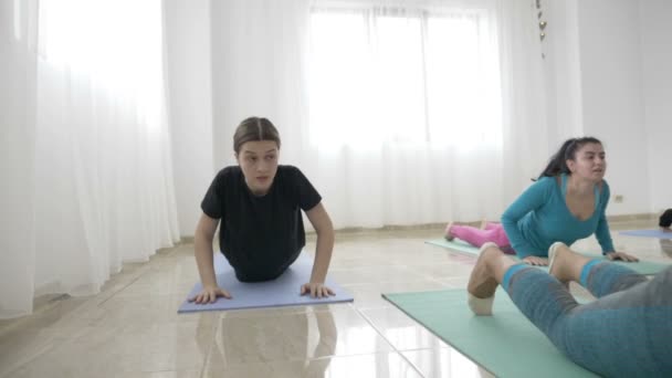 Grupp kvinnor tränar krigare yogaställning och mediterar i slow motion att komma över depression — Stockvideo