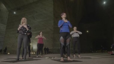Yetişkin orta yaşlı kadın kolları geniş meditasyon sırasında onların öğretim takip yoga egzersizleri yapıyor grup açık bir tuz benim