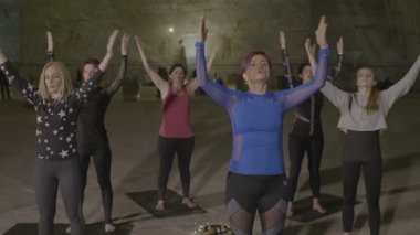 Kurumsal kadınlar için bir ekip oluşturma tuz duvarlar ve heykeller bir fitness mat üzerinde duran ve pilates ve nirvana pratik yapılmış bir yer içinde katılan