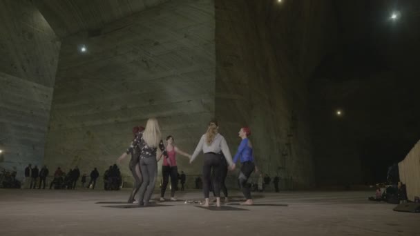 Mujeres atractivas y delgadas calentándose con ejercicios aeróbicos en una fría mina de sal subterránea — Vídeo de stock
