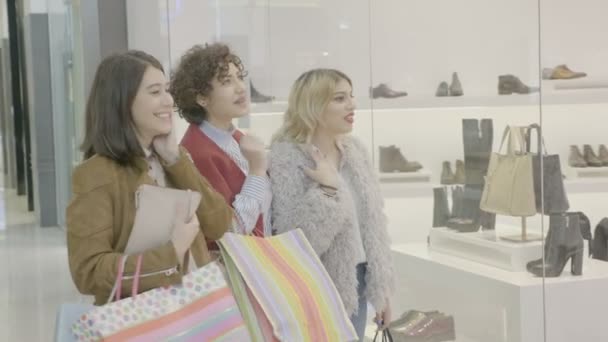 Krásné stylové módní mladých dívek v obchoďáku nosí drahé oblečení a budou chutnat a s reakcí na prodej vidí v obchodě okna — Stock video