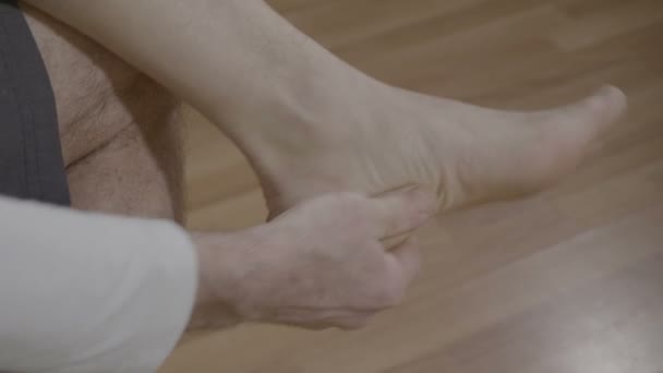 Homem aposentado relaxando-se com reflexoterapia massagem nos pés em casa — Vídeo de Stock