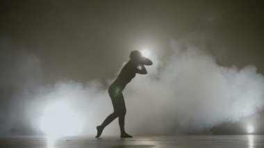 Genç güzel çekici kadın bir duman arka plan sahne üzerinde basit bir modern dans performans