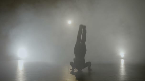 Young teenage hip hop male break dancer dancing on a set with smoke while filming for a famous pop music band — Stock Video