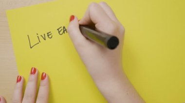 Eller kadın hayatını sadece siyah bir marker ile sarı bir kağıt üzerinde motivasyonel teklif başladı sanki her gün canlı yazma
