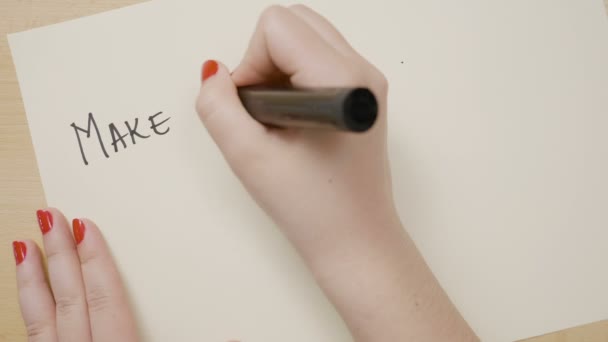 Ženských rukou psát, aby bylo možné zprávu a zdůraznění na bílém papíře s černou značkou — Stock video