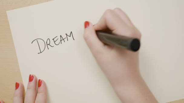 Женские руки пишут мечту большой и смело проваливают восклицательный знак мотивационной цитаты на белой бумаге с черным маркером — стоковое видео