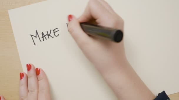Женский почерк делает каждый день ваш шедевр мотивационной цитатой на белой бумаге с черным маркером — стоковое видео
