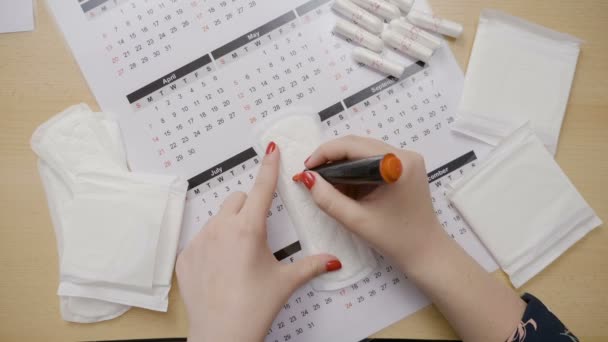 Teenage girl counting the days of her last ovulation and drawing question marks on tampon calendar and asking why her period is running late — Stock Video