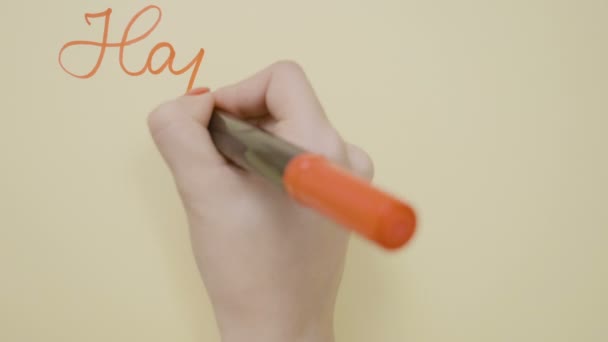 Visão superior de jovens mãos de menina adolescente escrevendo feliz dia dos namorados com um marcador vermelho em um cartão de saudação e desenhando um pouco de coração sobre ele — Vídeo de Stock