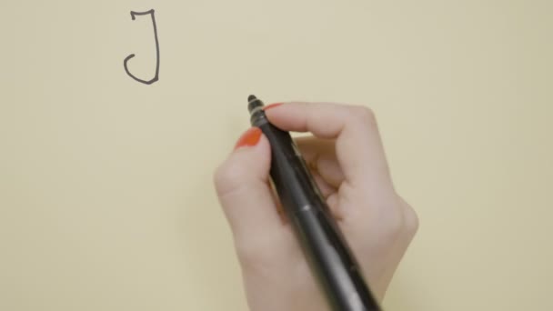 Vista superior de las manos femeninas escribiendo Te amo usando un marcador rojo y negro en una tarjeta de felicitación y dibujando un corazón — Vídeo de stock