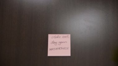 El yazısıyla yazılan yazı koyu ahşap çalışma masasında motivasyonel tırnak içeren notlar yapışmasını eller Üstten Görünüm
