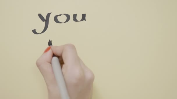 Girl hands writing motivational quote you only live once with black pen on a blank piece of paper — Stock Video