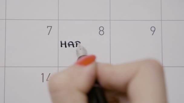 Le mani della donna segnano il giorno nel calendario scrivendo felice anniversario come promemoria usando una penna nera — Video Stock