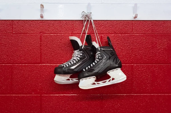 Hockey Schlittschuhe Hängen Der Umkleidekabine Über Rotem Hintergrund Mit Kopierraum — Stockfoto