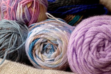 Örgü örmek ya da beyaz battaniyeli örgü örmek için renkli iplikçiklerin yakın görüntüsü 