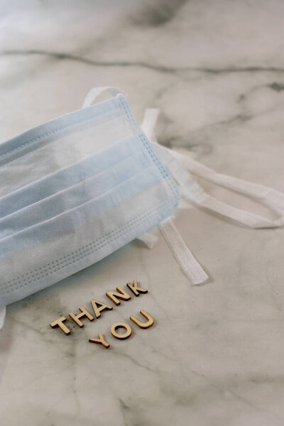 Хирургическая маска с благодарностью переписать мраморный фон с копировальным пространством. Вертикаль
 