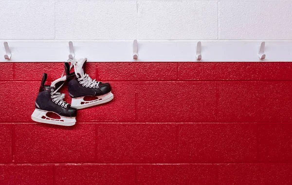 Hokejové Brusle Visí Přes Červenou Stěnu Šatně Kopírovacím Prostorem — Stock fotografie