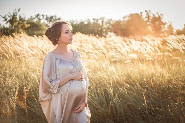 Porträtt av en gravid kvinna i solnedgången ljus — Stockfoto