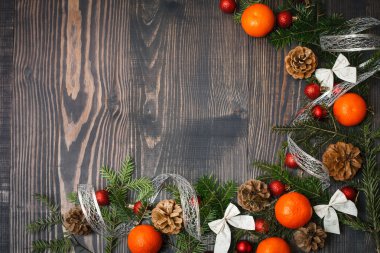 Kırmızı Noel topları, çam dalları ve mandalina