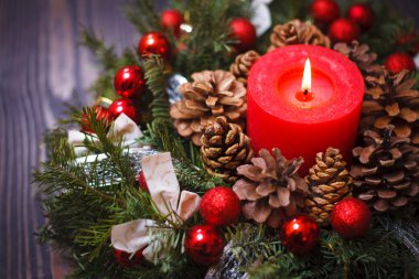 Çamın dalları Noel topları ile bir çelenk içinde kırmızı mum