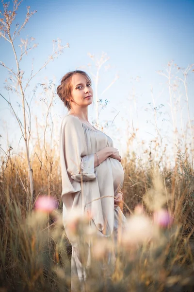 Retrato de una mujer embarazada bajo la luz del atardecer —  Fotos de Stock