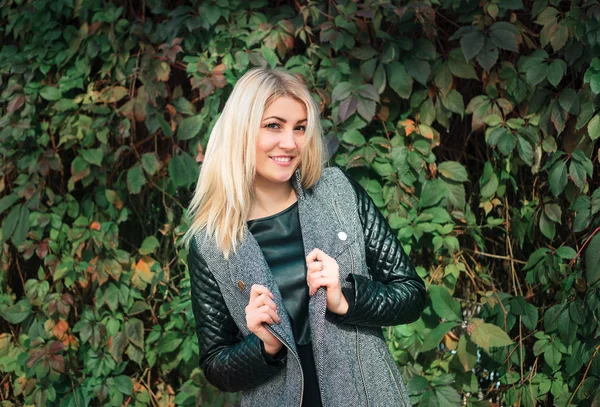 Attractive young woman on a background of ivy leaves — Stock Photo, Image