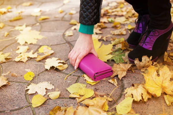 Woman raises a lost wallet on the street — Stock Photo, Image