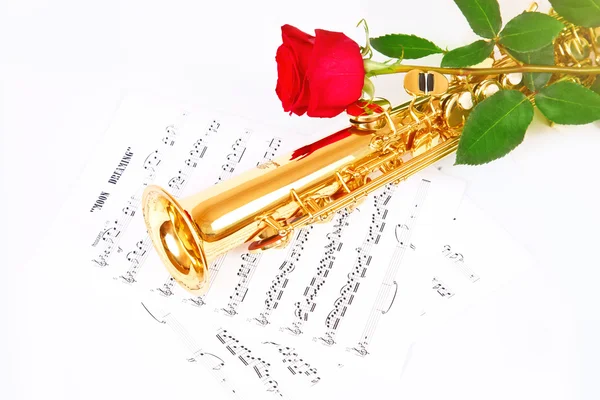 Rosa roja, saxofón y hoja de música — Foto de Stock