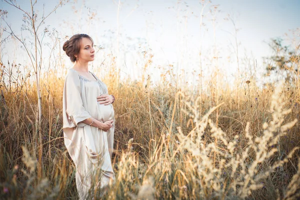 Porträtt av en gravid kvinna i solnedgången ljus — Stockfoto