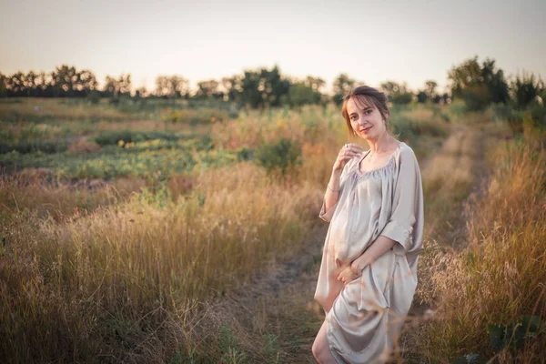 Porträt einer schwangeren Frau im Sonnenuntergang — Stockfoto