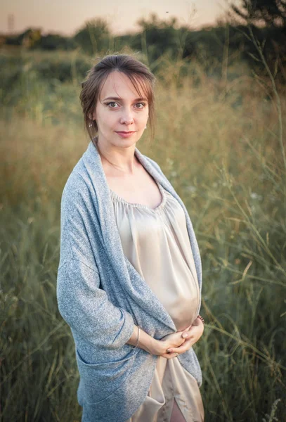 Porträtt av en ung vacker gravid kvinna på naturen. — Stockfoto